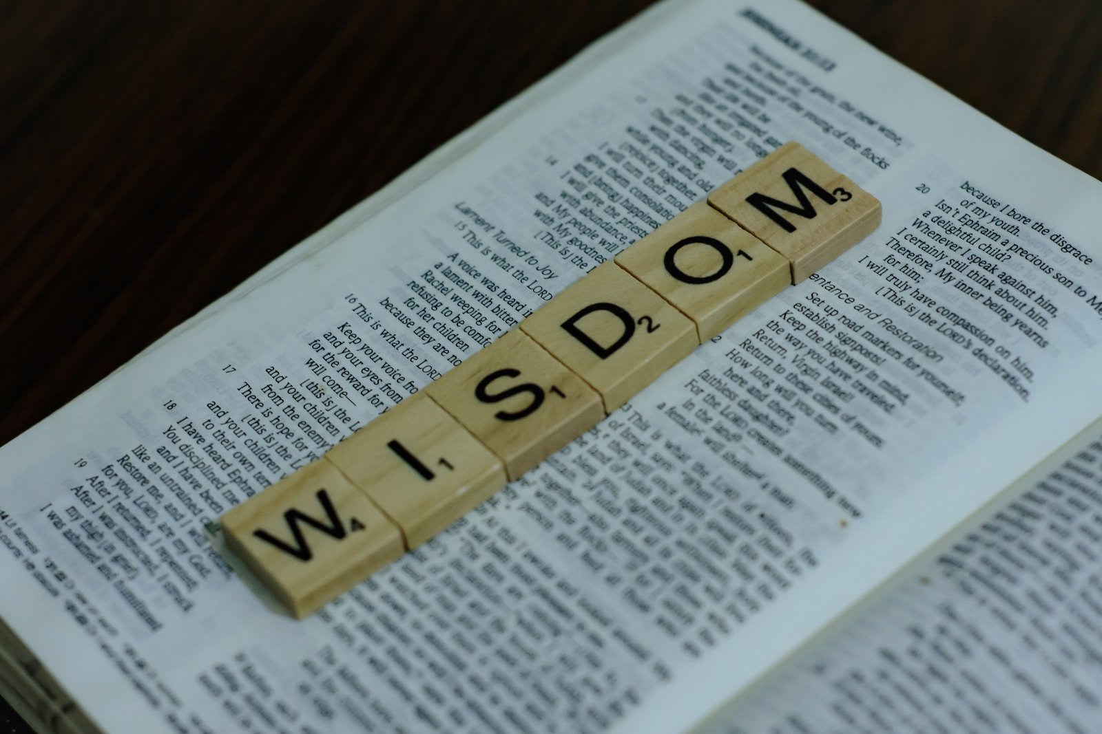 a scrabbled word spelling the word w is down on top of a, Wisdom