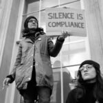 Silence is compliance - A protester with a message standing on a window ledge in Whitehall.