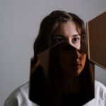 A unique portrait of a woman reflected in a broken mirror, evoking emotion and introspection.