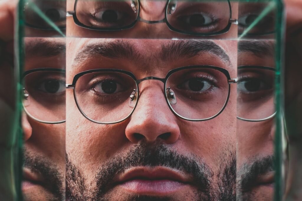 Creative close-up portrait with mirrored reflections, emphasizing facial features and eyeglasses.